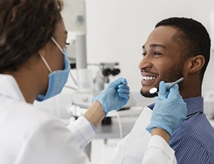 young man smiling at dentist while getting dental bonding in Carrollton 