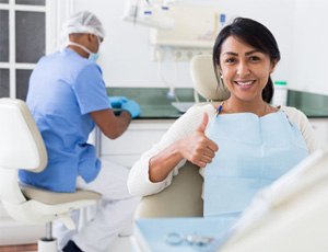 a patient smiling and giving a thumbs-up