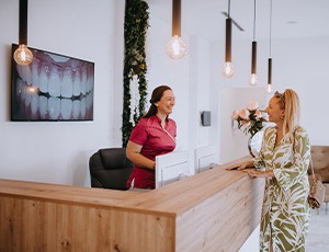 Patient and dental receptionist talking in lobby