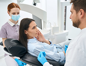 A woman talking to her dentist about a toothache