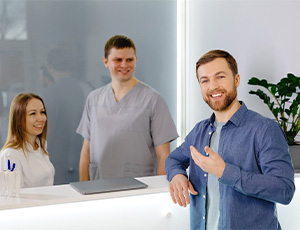 A man standing in a dental clinic who’s very pleased with his treatment results