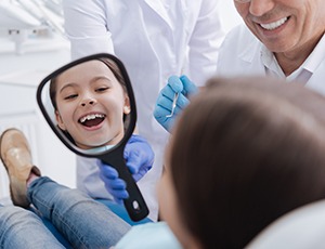 Young girl looking in mirror with healthy smile