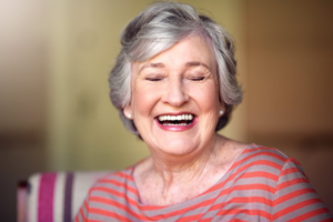 Senior woman smiling widely to show off dental implants